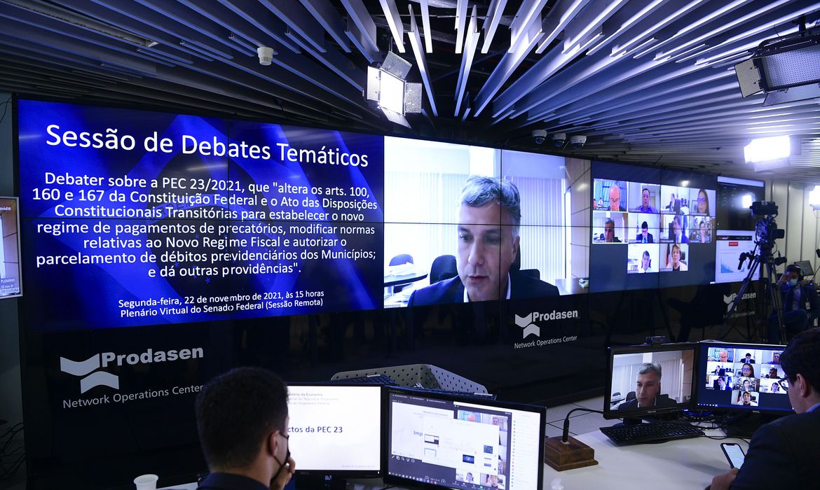 Sessão de debates temáticos, realizada a partir da sala de controle da Secretaria de Tecnologia da Informação (Prodasen), para debater sobre a Proposta de Emenda à Constituição (PEC) 23/2021, conhecida como PEC dos Precatórios. A PEC 23/2021, já aprovada pelos deputados, muda os critérios para o pagamento dos precatórios, altera o teto de gastos e abre espaço orçamentário para pagamento do programa Auxílio Brasil até o fim de 2022. Secretário de Orçamento do Ministério da Economia, Esteves Colnago, em pronunciamento via videoconferência. Participa presencialmente, diretor-executivo da Instituição Fiscal Independente (IFI) do Senado Federal, Felipe Scudeler Salto. Foto: Pedro França/Agência Senado